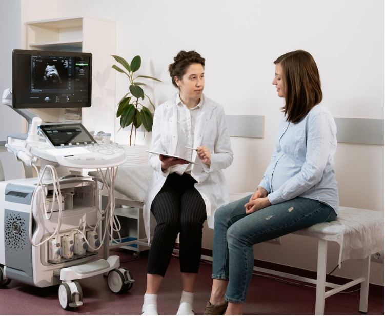 un docteur et une personne assis sur un lit avec une tablette dans les main