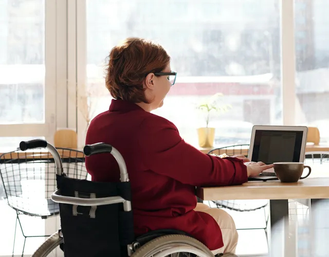Une femme dans un fauteuil roulant, utilisant une tablette
