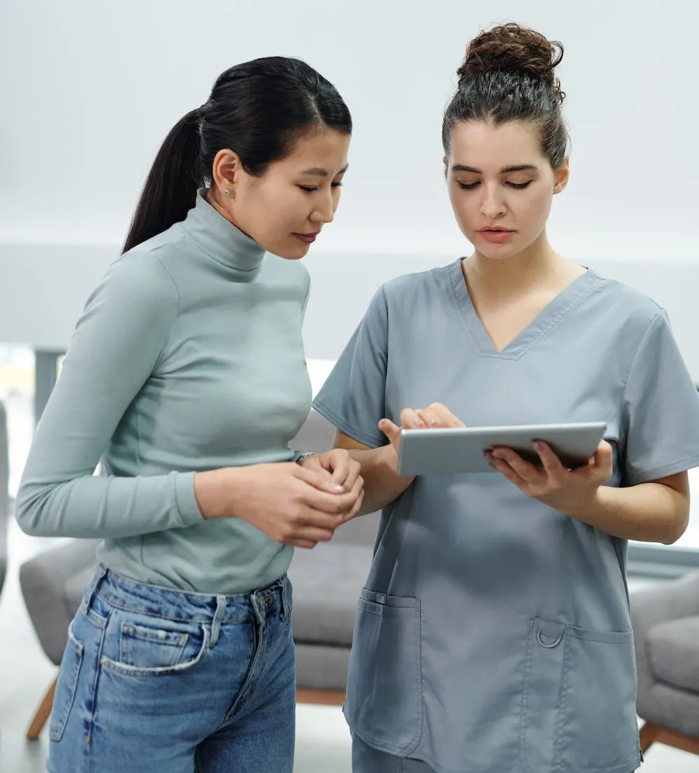 Deux femmes debout, regardant une tablette